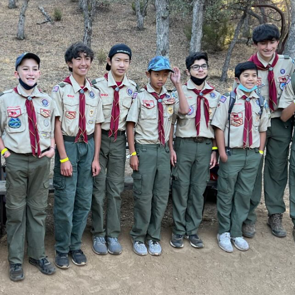 Scouts in uniform gathered together on a wooded trail