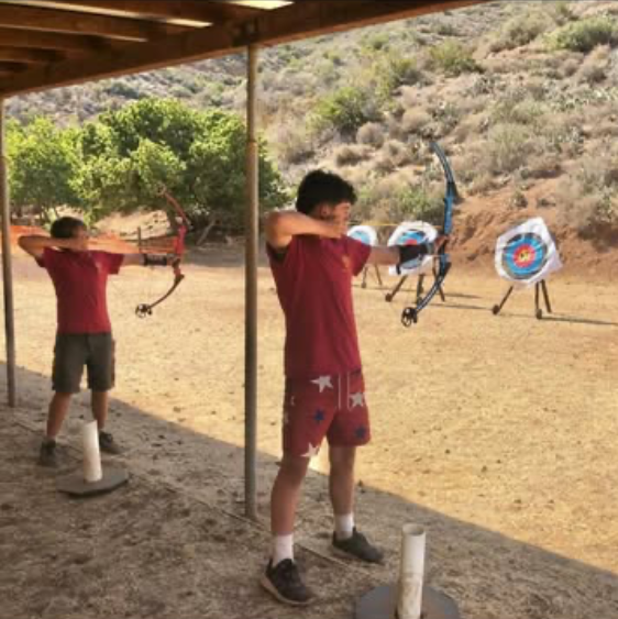 Scouts practicing archery at an outdoor range