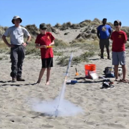 Scouts launching a model rocket on the beach